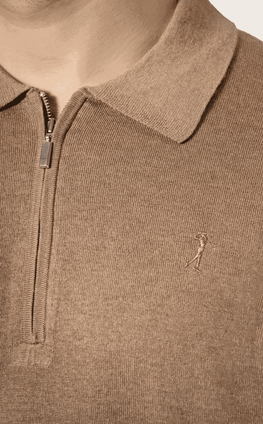 Close-up of a  silk polo shirt with a small logo on a neutral background